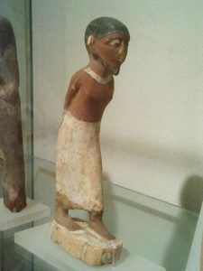 figurine from egypt of semitic slave, clay, shaven head, kohl eyes.
