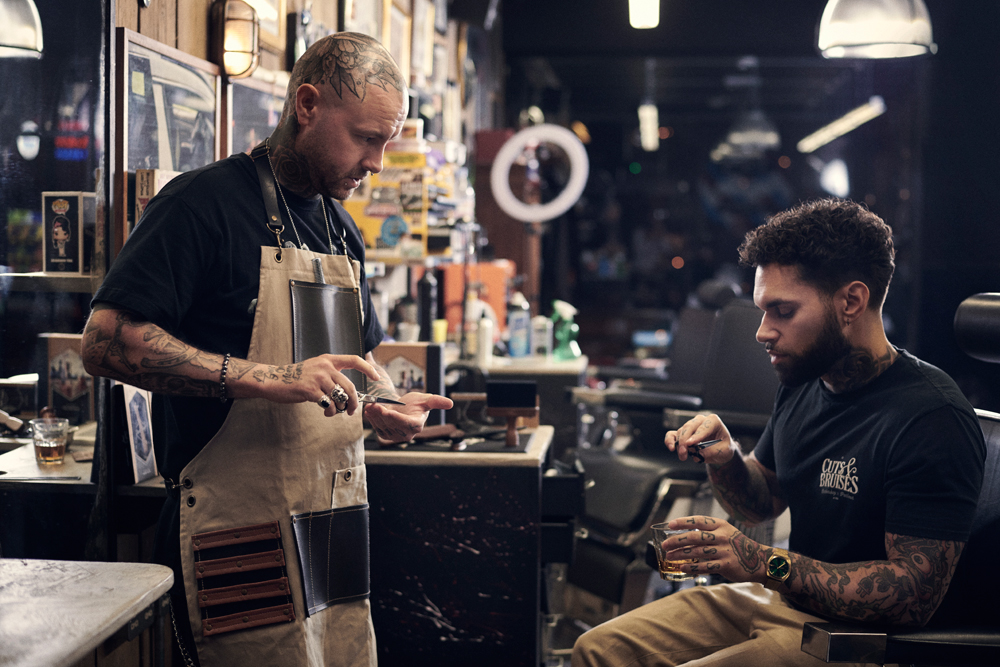 a barber wearing an apron inside a barbershop