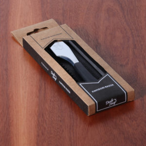 The Dark Stag Kamisori in packaging on wood